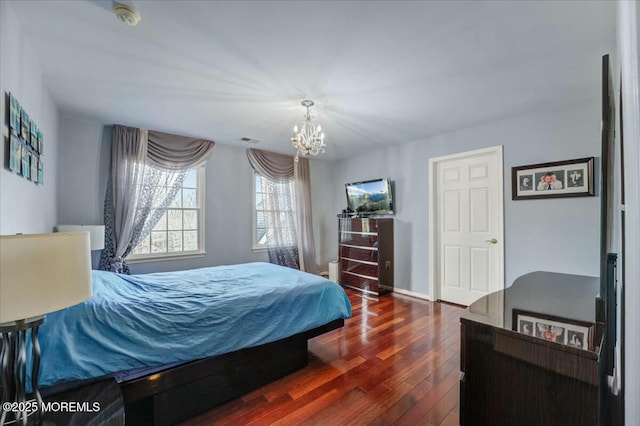 bedroom featuring an inviting chandelier and hardwood / wood-style flooring