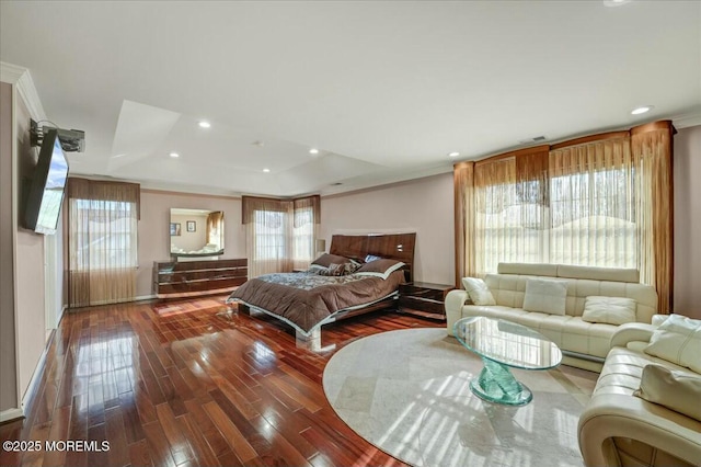 bedroom featuring dark hardwood / wood-style flooring, ornamental molding, and a raised ceiling