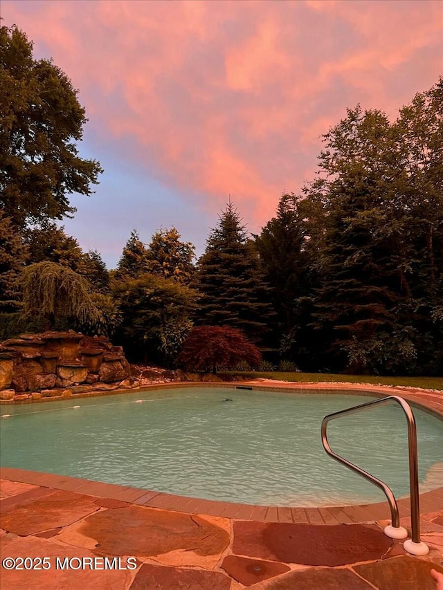 view of pool at dusk