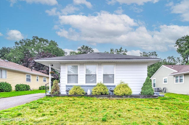 view of front of house featuring cooling unit and a front yard