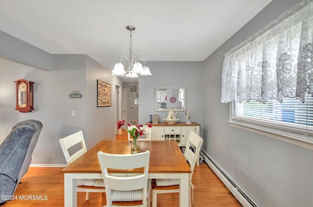 dining space with a baseboard heating unit, a chandelier, and light wood-type flooring