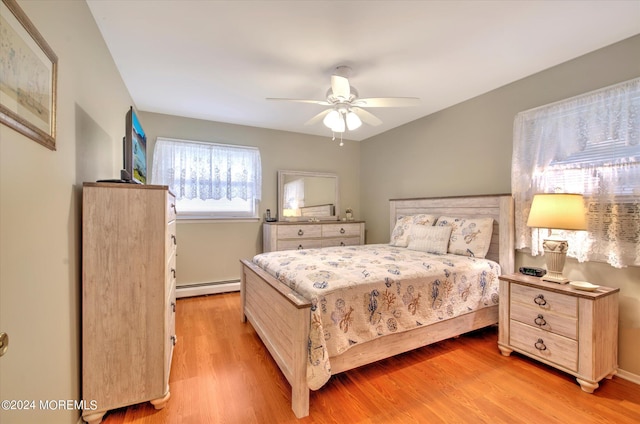 bedroom with light wood-type flooring, ceiling fan, and a baseboard radiator