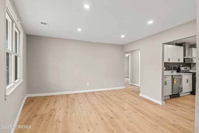 kitchen featuring sink, white cabinetry, stainless steel appliances, and light wood-type flooring