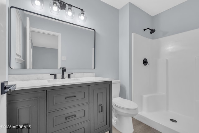 bathroom featuring walk in shower, vanity, toilet, and hardwood / wood-style flooring