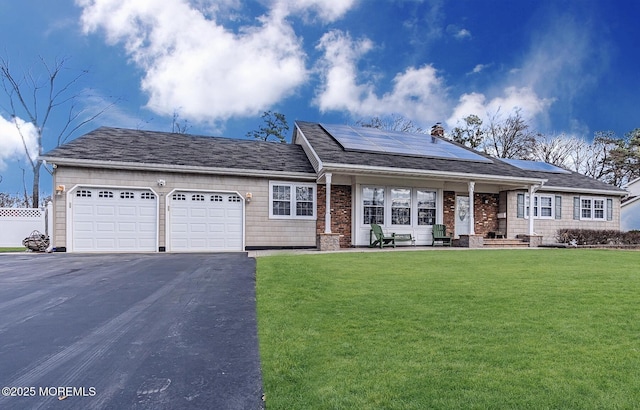 ranch-style house featuring a garage, a front yard, and solar panels