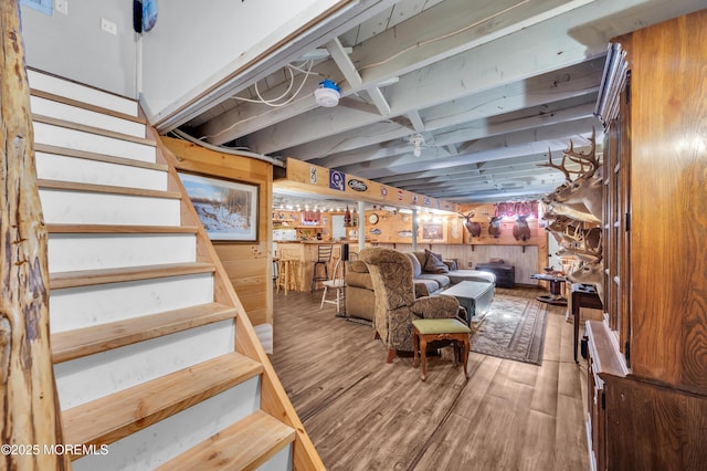 basement featuring hardwood / wood-style flooring and wood walls