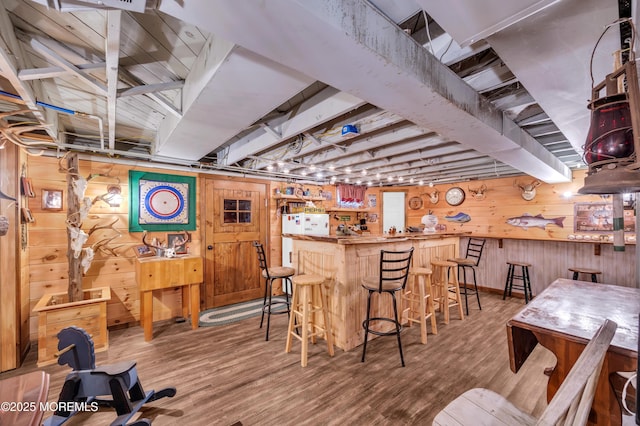 bar featuring hardwood / wood-style flooring and wooden walls