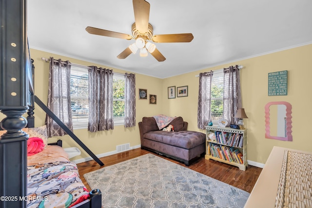 bedroom with ceiling fan, dark wood-type flooring, and ornamental molding