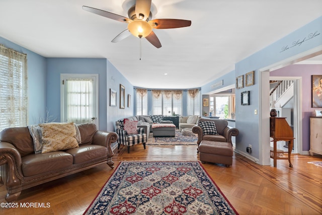 living room featuring ceiling fan, a wealth of natural light, and light parquet floors