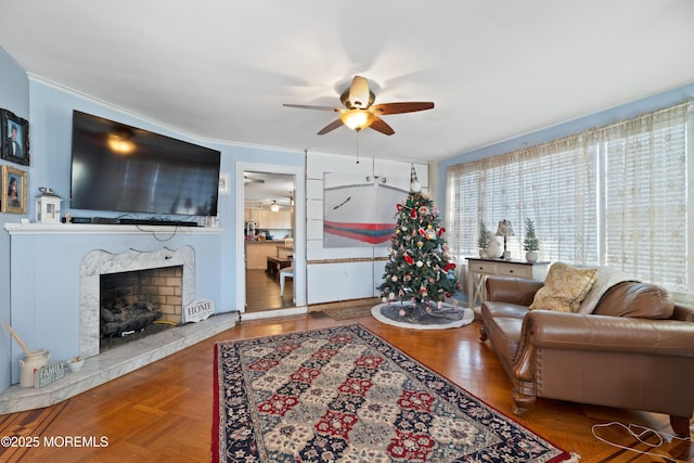 living room with ceiling fan, parquet flooring, and a fireplace