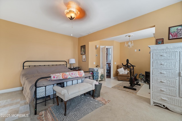 carpeted bedroom with ceiling fan with notable chandelier