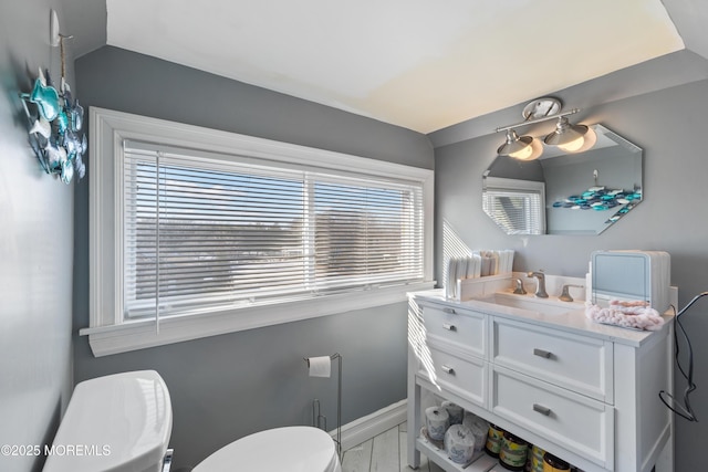 bathroom with toilet, plenty of natural light, and vanity