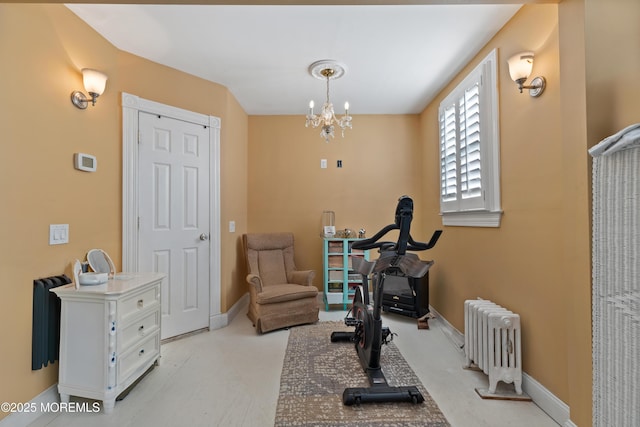 workout area featuring a notable chandelier and radiator heating unit