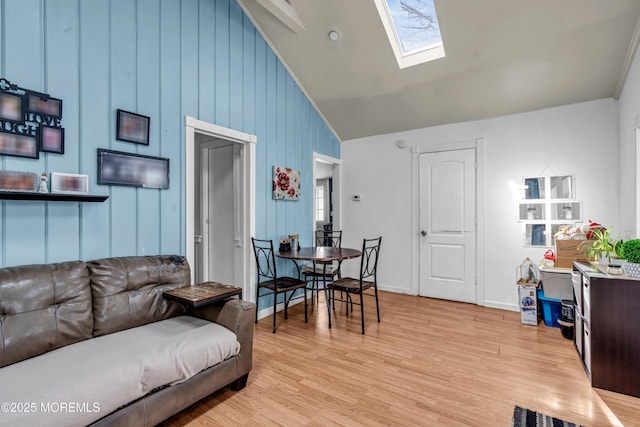 living room with vaulted ceiling with skylight and light wood-type flooring