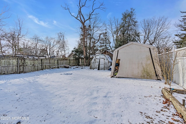 yard layered in snow with a storage shed