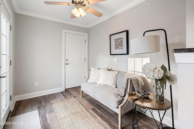 sitting room featuring dark wood-type flooring, ornamental molding, and ceiling fan