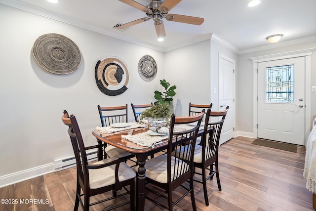 dining space featuring hardwood / wood-style flooring, ornamental molding, ceiling fan, and baseboard heating