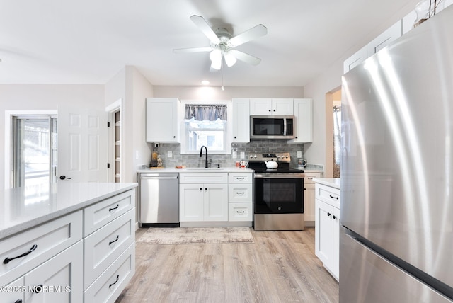 kitchen featuring white cabinetry, sink, decorative backsplash, and appliances with stainless steel finishes