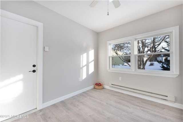 empty room featuring a baseboard radiator, ceiling fan, and light wood-type flooring