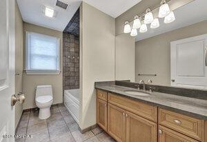 full bath featuring  shower combination, vanity, toilet, and tile patterned floors