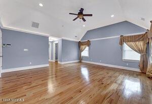 interior space with plenty of natural light, vaulted ceiling, and wood finished floors