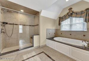 full bath with a stall shower, a garden tub, lofted ceiling, and tile patterned floors