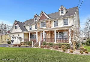 view of front of property featuring a garage, a front lawn, and a porch