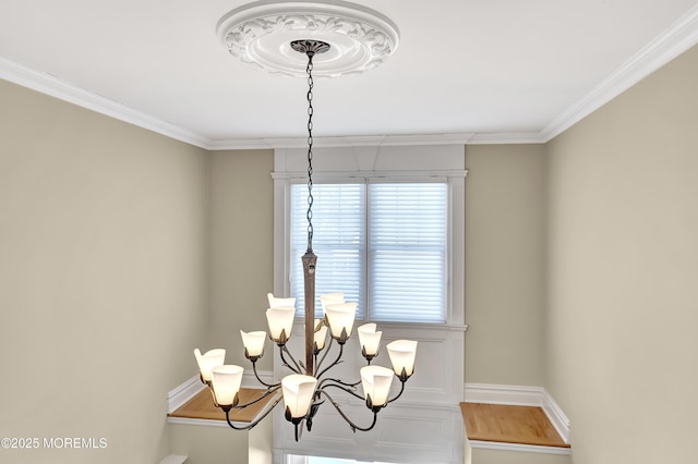 details featuring a chandelier, crown molding, and baseboards