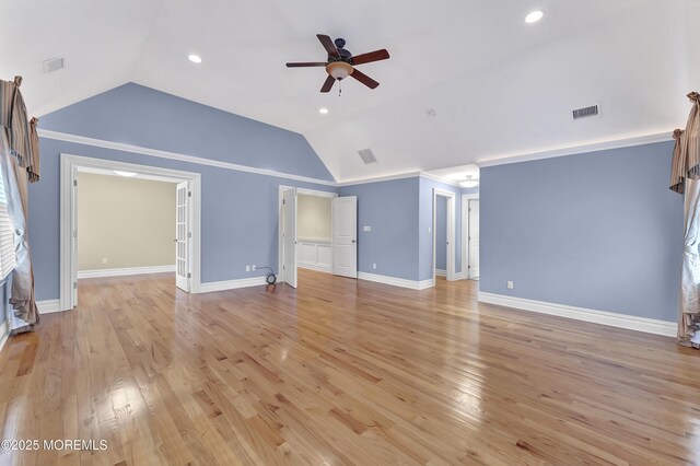 unfurnished living room featuring lofted ceiling, visible vents, ceiling fan, light wood-type flooring, and baseboards