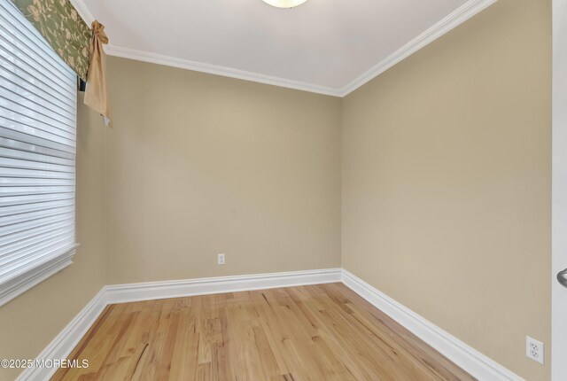 spare room with ornamental molding, wood finished floors, and baseboards