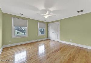 unfurnished bedroom with light wood finished floors, baseboards, and visible vents