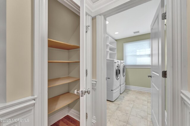 clothes washing area with laundry area, baseboards, visible vents, and washer and dryer