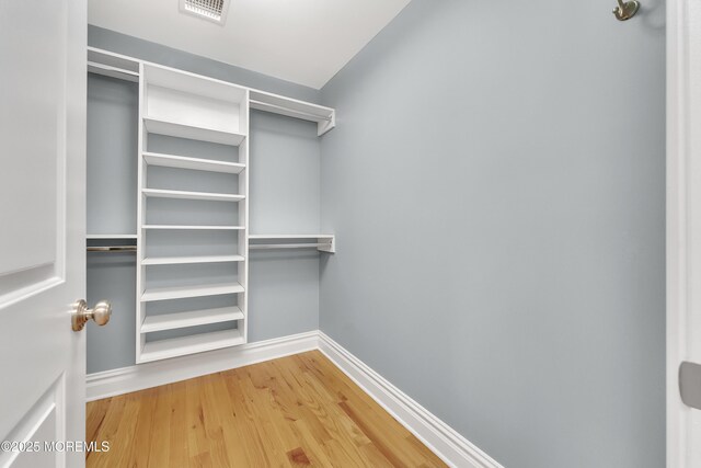 walk in closet featuring wood finished floors and visible vents