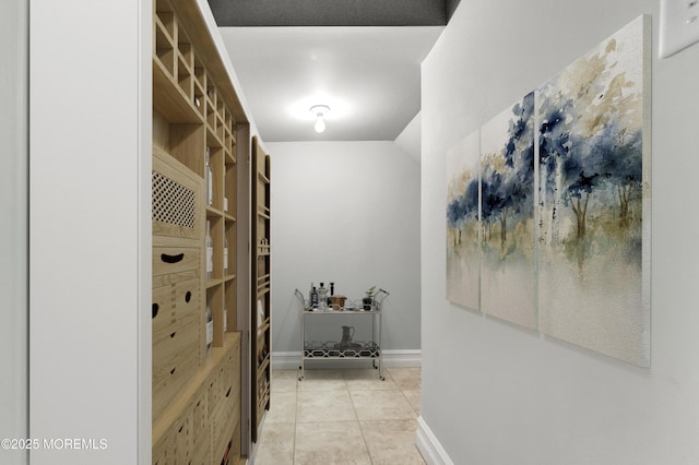 interior space featuring light tile patterned flooring and baseboards