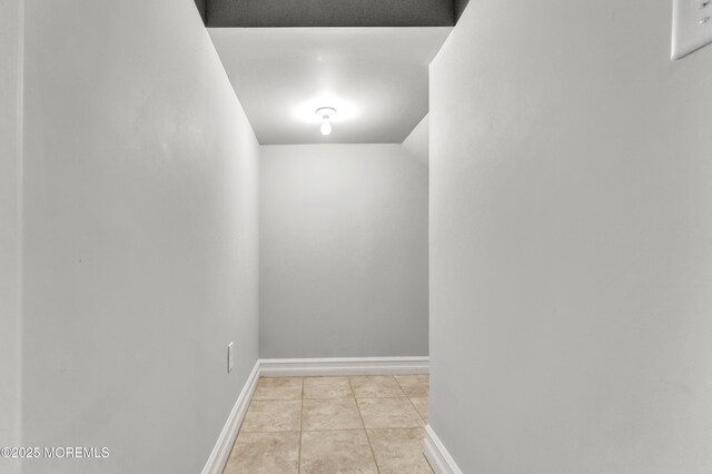 hallway featuring light tile patterned floors and baseboards