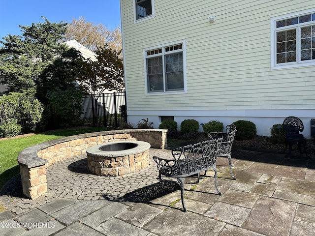 view of patio featuring fence and a fire pit