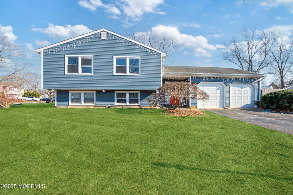 split level home featuring a garage and a front yard