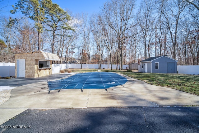 view of pool featuring an outbuilding, a patio, and a garage