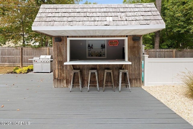 deck featuring a grill and a bar