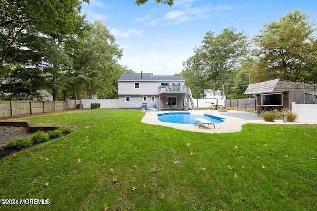 rear view of house featuring a fenced in pool, a patio area, and a lawn