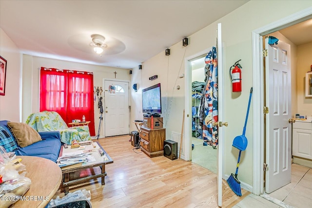 living room featuring ceiling fan and light wood-type flooring