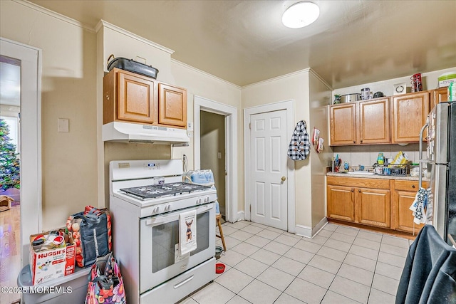 kitchen with light tile patterned floors, stainless steel fridge, crown molding, and white gas range