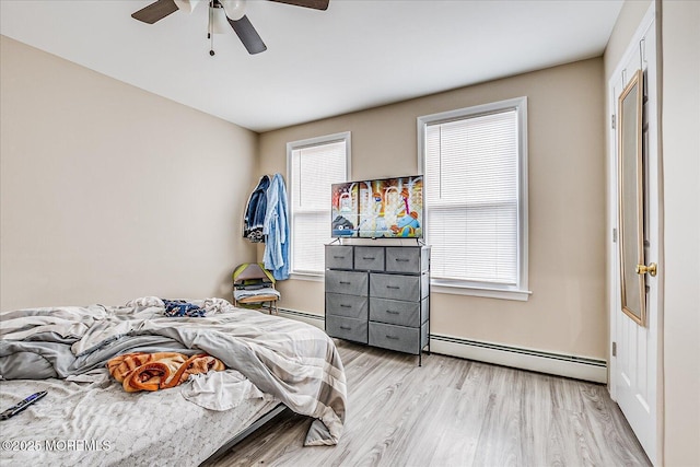 bedroom with ceiling fan, light hardwood / wood-style flooring, and a baseboard radiator