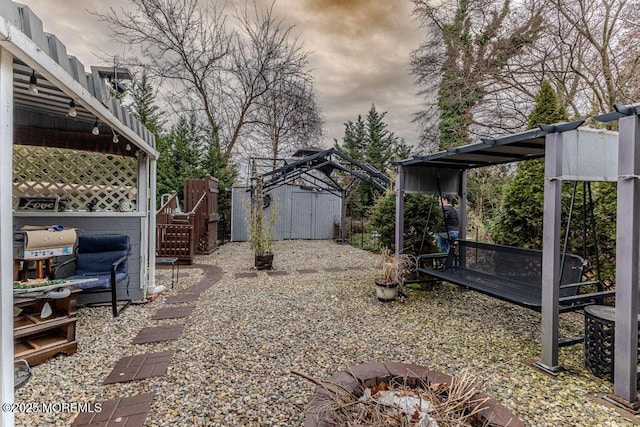 view of yard featuring an outdoor fire pit and a shed