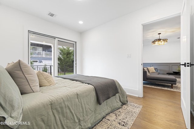 bedroom with a notable chandelier and light hardwood / wood-style flooring