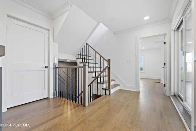 foyer entrance featuring plenty of natural light, light hardwood / wood-style flooring, and crown molding