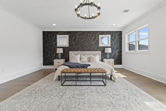 bedroom featuring dark hardwood / wood-style flooring, ornamental molding, and a notable chandelier