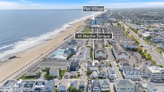 drone / aerial view featuring a water view and a beach view