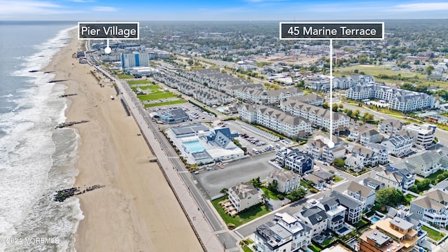 birds eye view of property featuring a water view and a beach view