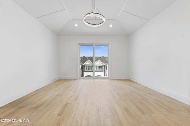 spare room with lofted ceiling and light hardwood / wood-style flooring